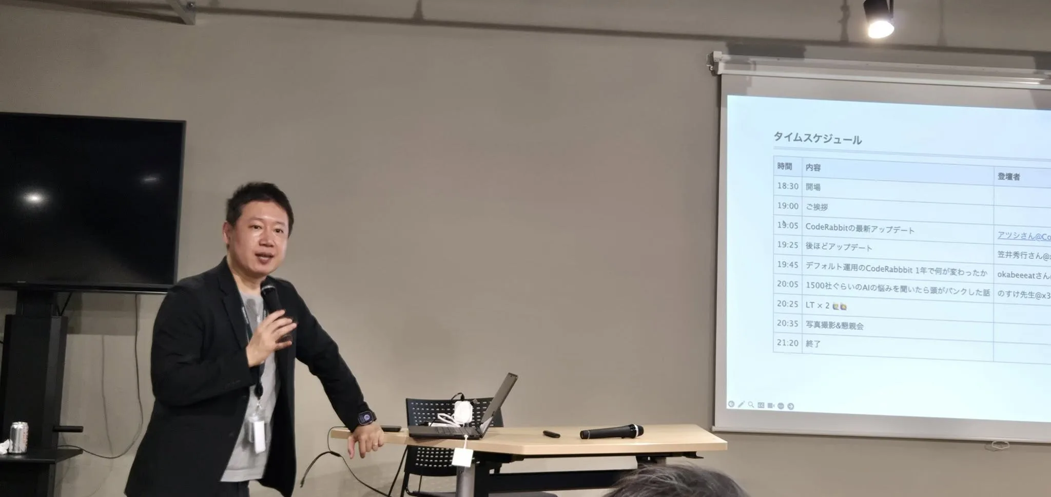 マイクを持って登壇し講演する代表の武石幸之助